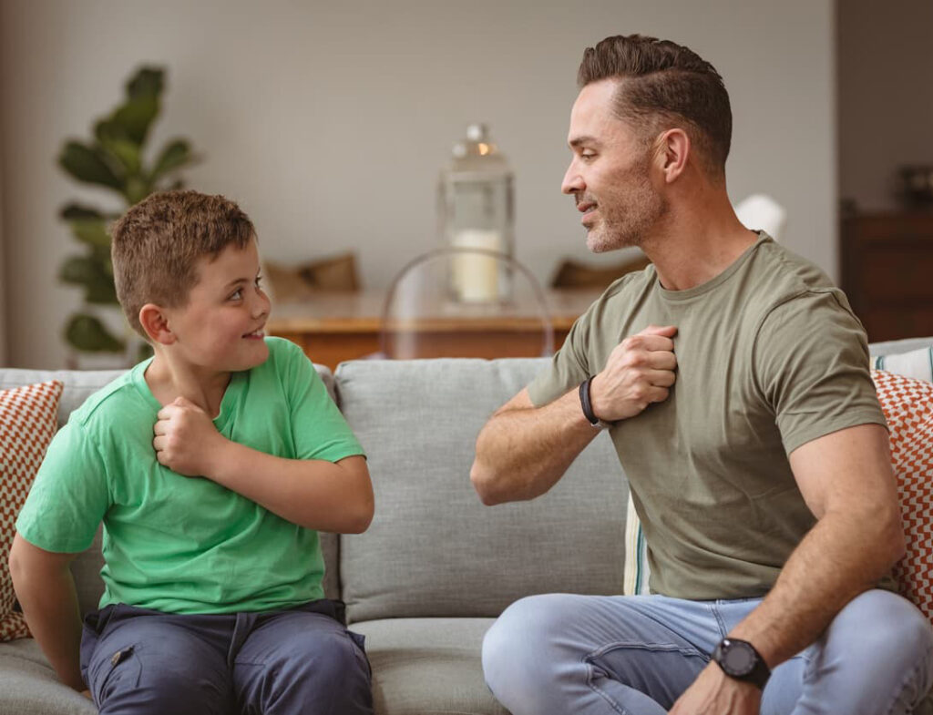 Support worker communicating with a child using gestures on a couch